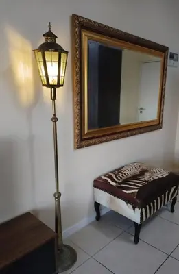 a lamp and a ottoman in a room with a mirror at Blouberg Luxury Oasis With Pool & Scenic Mountain Views in Cape Town
