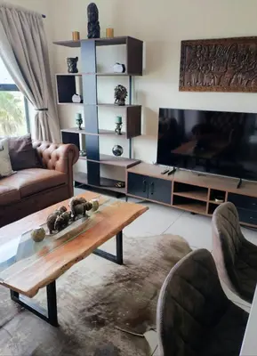 a living room with a coffee table and a flat screen tv at Blouberg Luxury Oasis With Pool & Scenic Mountain Views in Cape Town