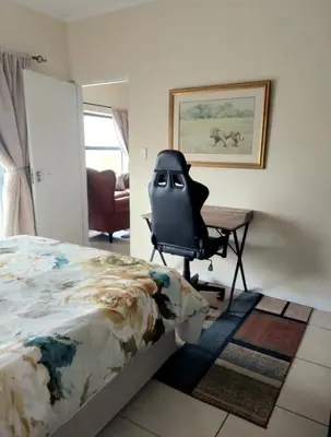 a bedroom with a desk and a chair next to a bed at Blouberg Luxury Oasis With Pool & Scenic Mountain Views in Cape Town