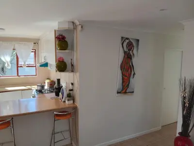 a kitchen with a refrigerator with a painting on it at Neats Accommodations in Cape Town