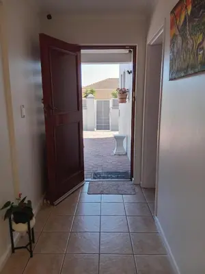 a hallway with a door and a tile floor at Neats Accommodations in Cape Town