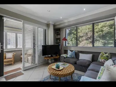 a living room with a couch and a tv at Merweda Wag-n-Bietjie on Dorp Street in Stellenbosch