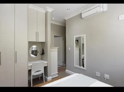a white room with a desk and a mirror at Merweda Wag-n-Bietjie on Dorp Street in Stellenbosch