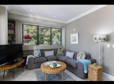 a living room with a couch and a table at Merweda Wag-n-Bietjie on Dorp Street in Stellenbosch