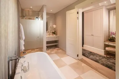 a bathroom with a tub and a toilet and a sink at Leeu Estates in Franschhoek