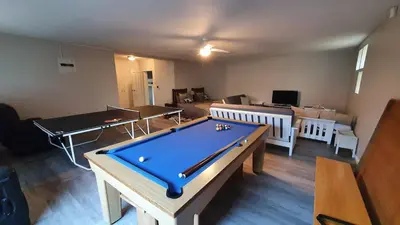 a living room with a pool table and two tables at Somerset Breeze