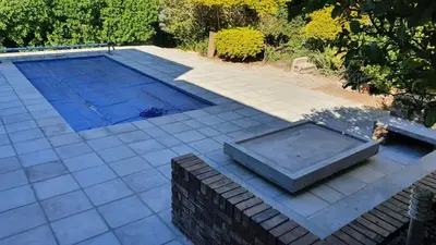 a swimming pool in a yard with a tile patio at Somerset Breeze