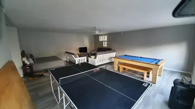 a living room with a ping pong table in it at Somerset Breeze
