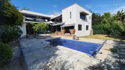 a house with a swimming pool in front of it at Somerset Breeze