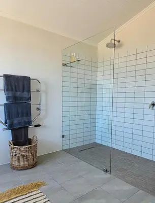 a bathroom with a glass shower with a towel at Tamatiebank in Hermanus