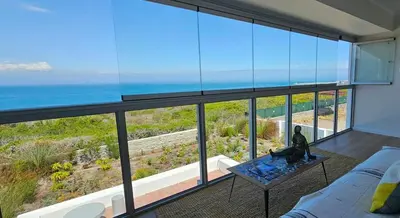 a living room with a view of the ocean at Tamatiebank in Hermanus