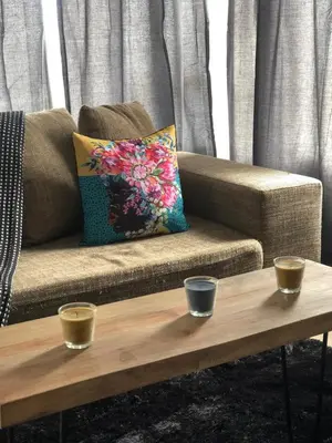 a coffee table in front of a couch with two candles on it at Brackenfell self catering accommodation in Brackenfell