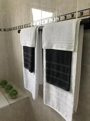 three towels hanging on a rack in a bathroom at Brackenfell self catering accommodation in Brackenfell