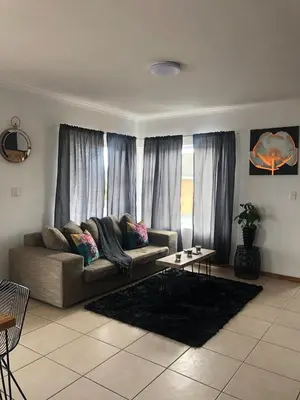 a living room with a couch and a table at Brackenfell self catering accommodation in Brackenfell