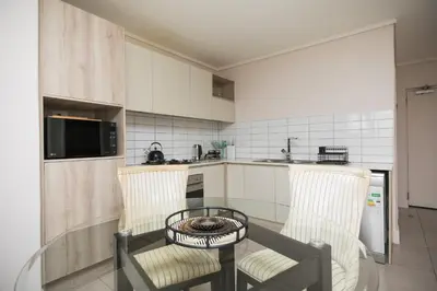 a kitchen with a table and two chairs and a table at 2 Bedroom Waters Edge Apartment in Century City in Cape Town