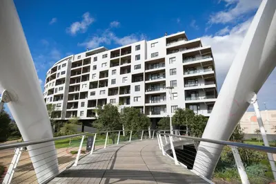 a white building with a bridge in front of it at 2 Bedroom Waters Edge Apartment in Century City in Cape Town