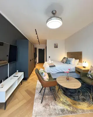 a bedroom with a bed and a living room at Promise on Nine Palms Century in Cape Town