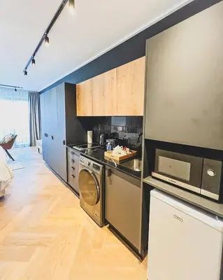 a kitchen with a washer and a stove and a microwave at Promise on Nine Palms Century in Cape Town