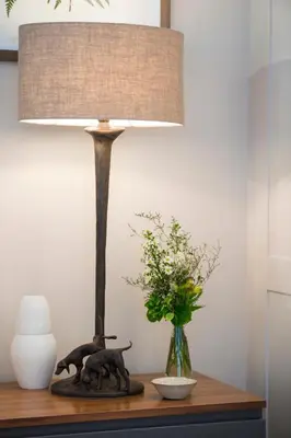 a lamp on a table next to a vase at Leeu House in Franschhoek