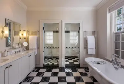 a bathroom with a black and white checkered floor at Leeu House in Franschhoek