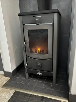 a wood stove in a corner of a room at Suite Vos in Hermanus