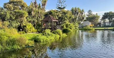 a gazebo on the side of a lake at The Island Beach House in Cape Town