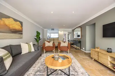 a living room with a couch and a table at The Island Beach House in Cape Town
