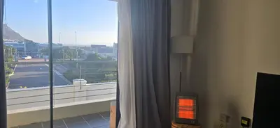 a room with a window with a view of a city at 118 on the Bay in Gordonʼs Bay