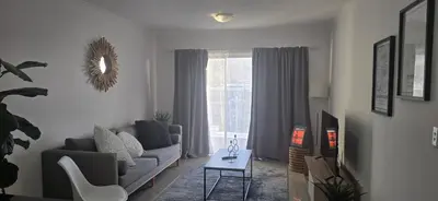 a living room with a couch and a window at 118 on the Bay in Gordonʼs Bay