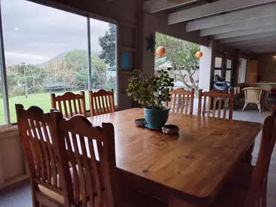 a wooden table with chairs and a potted plant on it at Pik 'n Wyntjie in Bettyʼs Bay