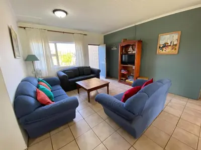 a living room with two blue couches and a table at Pik 'n Wyntjie in Bettyʼs Bay