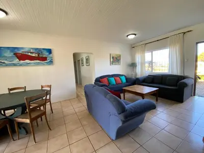 a living room with a blue couch and a table at Pik 'n Wyntjie in Bettyʼs Bay