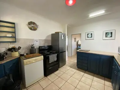 a kitchen with a black refrigerator and a stove at Pik 'n Wyntjie in Bettyʼs Bay