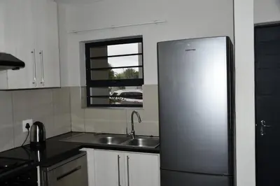 a kitchen with a stainless steel refrigerator and a sink at Avon Sand in Cape Town