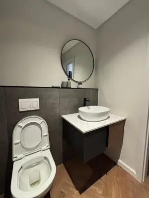 a bathroom with a toilet and a sink and a mirror at Modern chic at On park Century City near Canal Walk in Cape Town