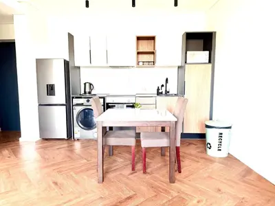a kitchen with a table and two chairs in a room at Modern chic at On park Century City near Canal Walk in Cape Town