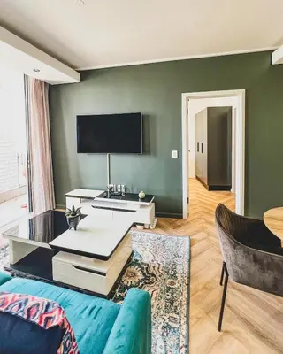 a living room with a couch and a tv at Agape Apartment On park Century in Cape Town