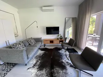 a living room with a couch and a table at Stellenbosch Rozendal Apartment in Stellenbosch