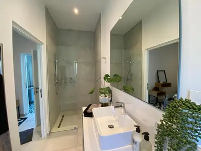 a bathroom with a sink and a shower and a mirror at Stellenbosch Rozendal Apartment in Stellenbosch