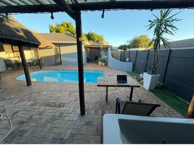 a patio with a table and a swimming pool at Joy House in Cape Town