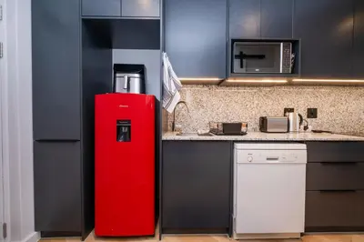 a red refrigerator in a kitchen next to a counter at Paarl Studio With Onsite Parking & Modern Comforts in Paarl
