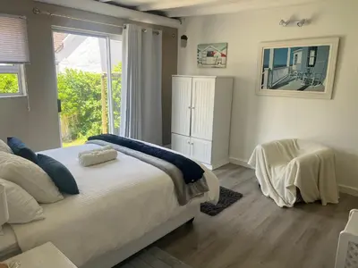 a bedroom with a large bed and a window at Golfers paradise on 25th green in Hermanus