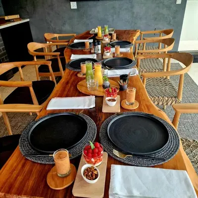 a wooden table with black plates and fruit on it at Tide and Timber Luxury Guesthouse in Hermanus