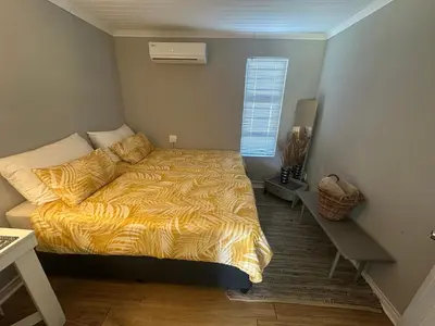 a bedroom with a bed with a yellow comforter and a window at Cozy and convenient in Oakdale