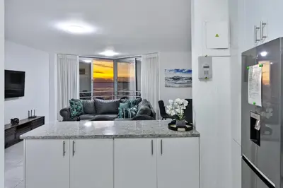 a kitchen with a counter top and a living room at Panoramic Seaview @ Strand in Strand