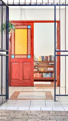 a red door in a room with a book shelf at Rivers Edge Loft in Wellington