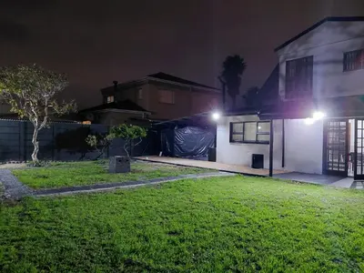 a house with lights on the side of it at night at Rihla Residences - Civic Road in Cape Town