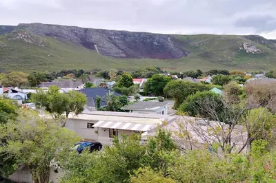 a small town with a mountain in the background at Stylish Apartment in Hermanus in Hermanus