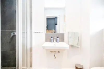 a white bathroom with a sink and a shower at Paarl - Lux Modern 2 Bedroom Apartment with Parking in Paarl