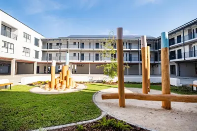 a park with wooden poles in front of a building at Paarl - Lux Modern 2 Bedroom Apartment with Parking in Paarl